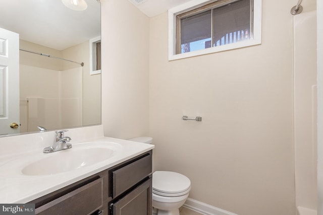 bathroom featuring toilet, a shower, and vanity