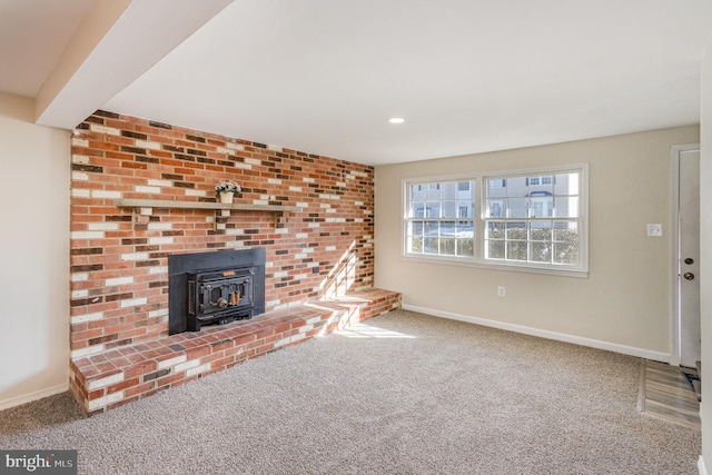 unfurnished living room featuring carpet floors and a wood stove