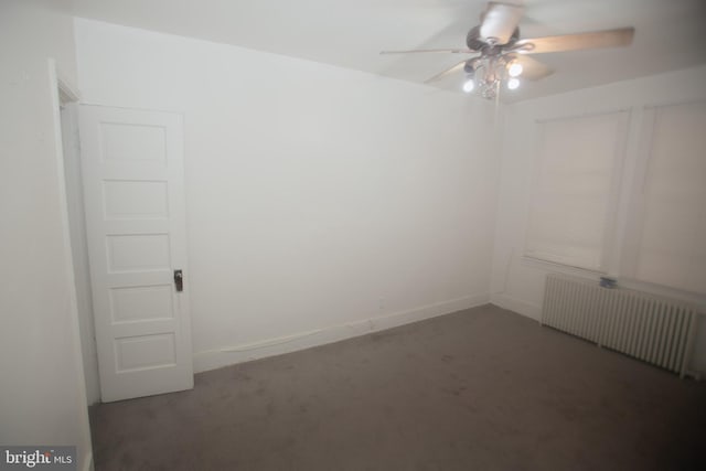 carpeted empty room with ceiling fan and radiator