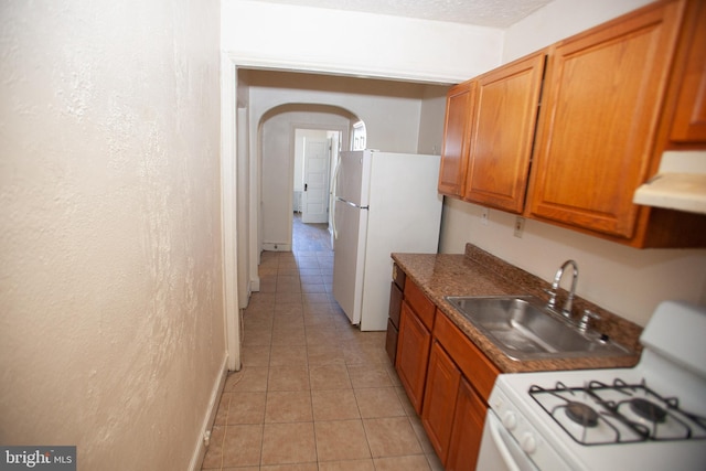 kitchen with white appliances, extractor fan, and sink