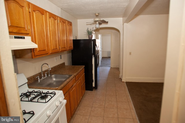 kitchen featuring sink, white gas stove, black fridge, a textured ceiling, and ceiling fan