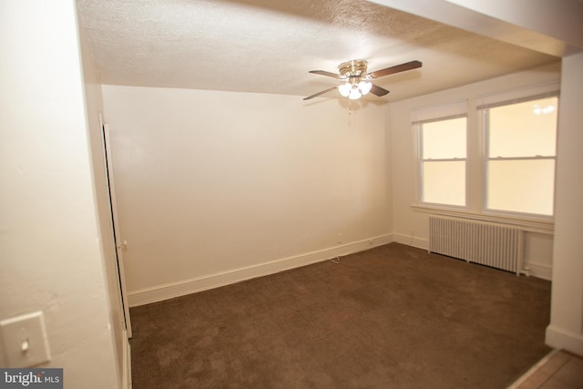 spare room with dark colored carpet, radiator heating unit, a textured ceiling, and ceiling fan