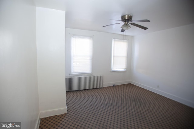 unfurnished room featuring carpet floors, radiator, and ceiling fan