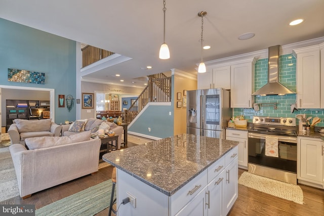 kitchen with white cabinetry, appliances with stainless steel finishes, and wall chimney range hood