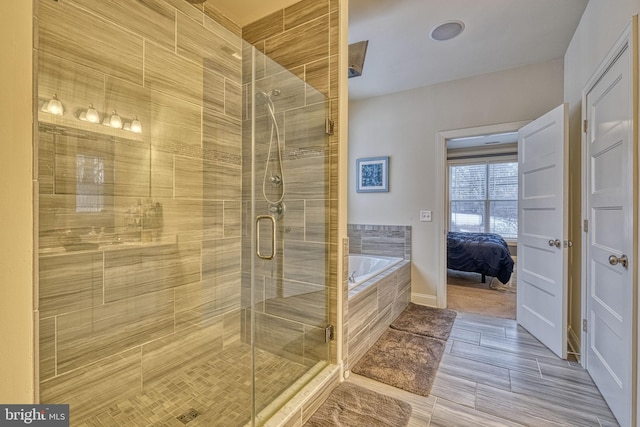 bathroom featuring shower with separate bathtub