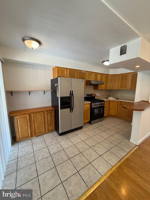 kitchen with decorative backsplash, sink, appliances with stainless steel finishes, and light tile patterned flooring