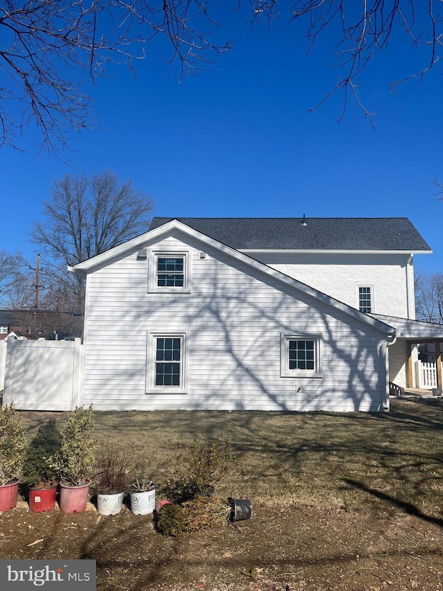 view of property exterior with a yard and fence