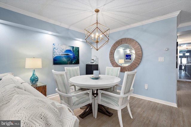 dining room featuring crown molding, a chandelier, and hardwood / wood-style flooring