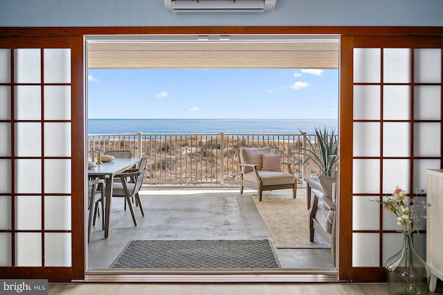 balcony with a water view and a wall mounted air conditioner