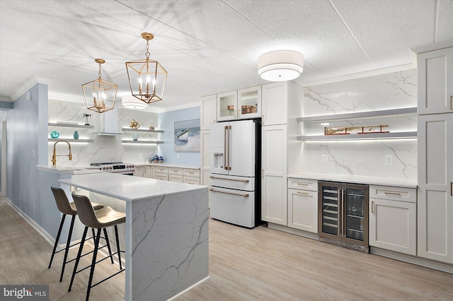 kitchen featuring white cabinetry, wine cooler, and high end white fridge