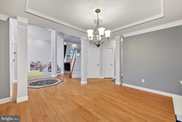 dining space featuring crown molding, hardwood / wood-style floors, a notable chandelier, and a raised ceiling