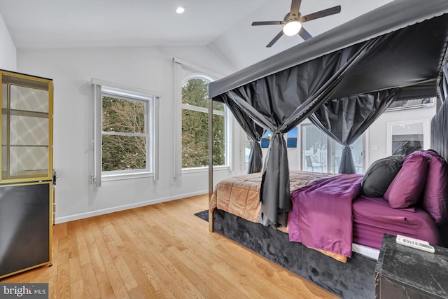 bedroom featuring light wood-type flooring, vaulted ceiling, and ceiling fan