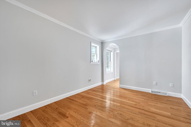 empty room with light hardwood / wood-style flooring and crown molding