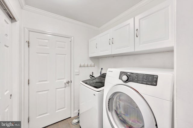 washroom with tile patterned floors, crown molding, cabinets, and washer and dryer