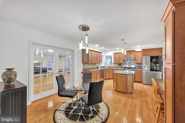 dining space with crown molding, sink, light hardwood / wood-style flooring, and french doors