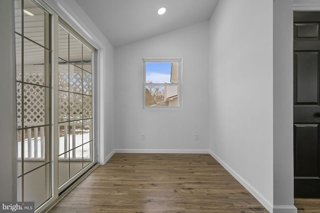 unfurnished room featuring dark hardwood / wood-style floors and vaulted ceiling