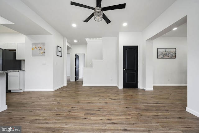 unfurnished living room featuring ceiling fan and dark hardwood / wood-style flooring