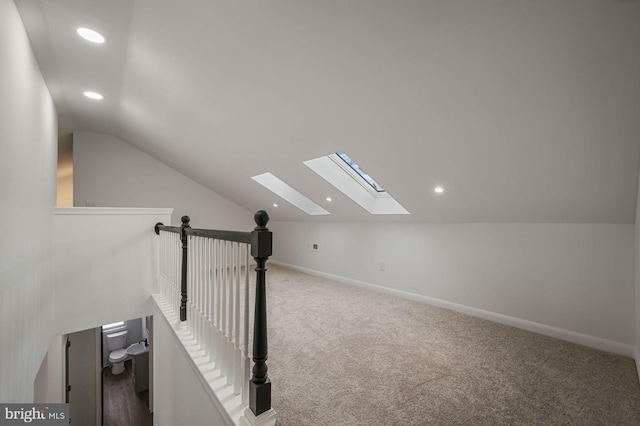 additional living space featuring carpet flooring and vaulted ceiling with skylight