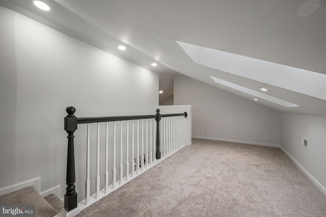 additional living space featuring carpet floors and vaulted ceiling with skylight