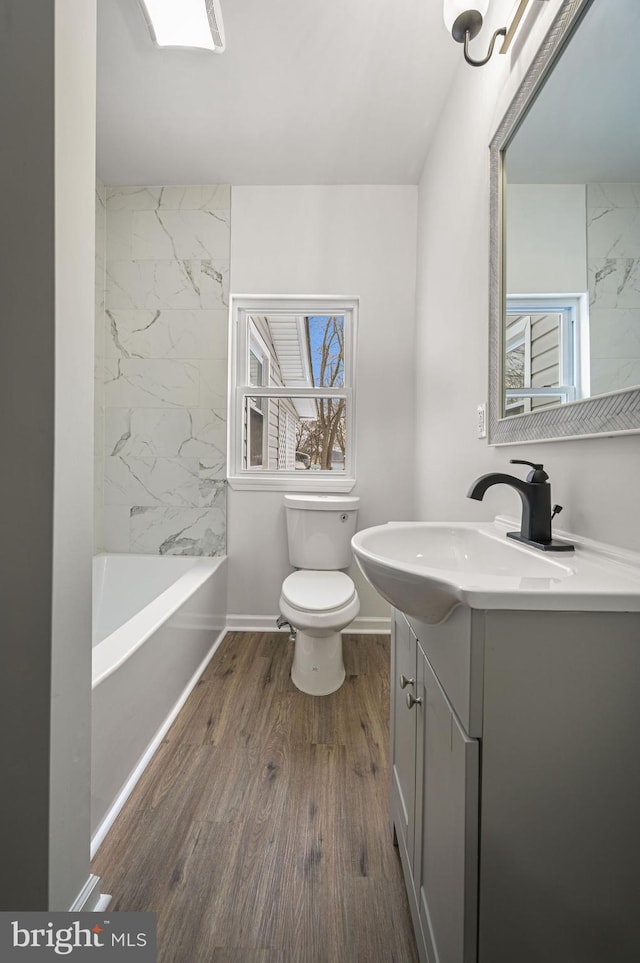 full bathroom featuring vanity, toilet, hardwood / wood-style floors, and tiled shower / bath