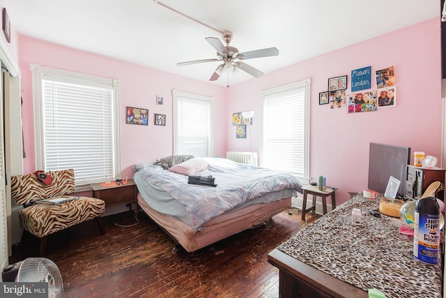 bedroom featuring dark hardwood / wood-style floors, radiator, and ceiling fan