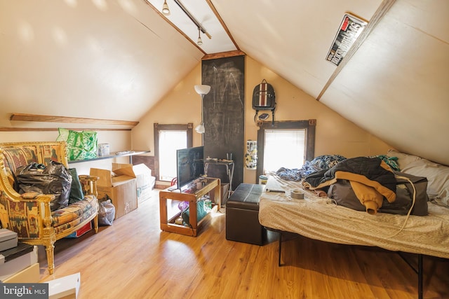 bedroom with multiple windows, lofted ceiling, and light hardwood / wood-style flooring