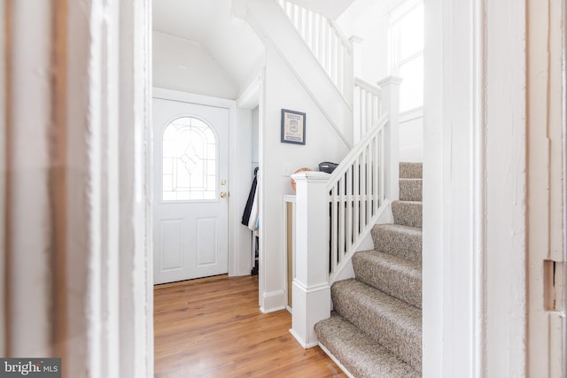 entryway with lofted ceiling and wood-type flooring