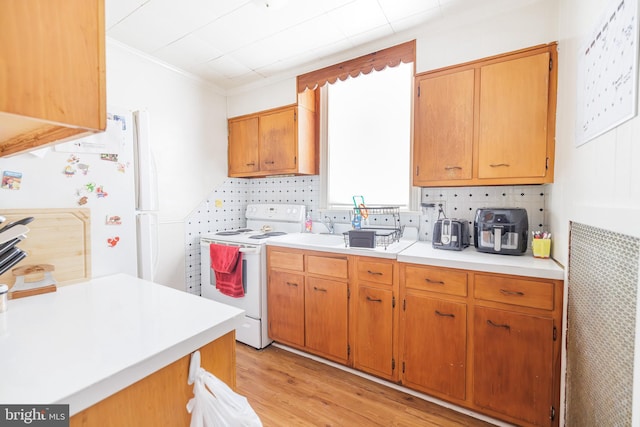 kitchen with white appliances, decorative backsplash, and light wood-type flooring