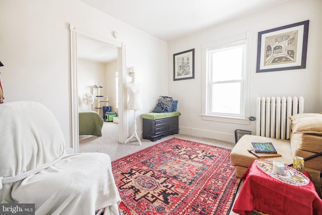 living area with radiator heating unit and carpet