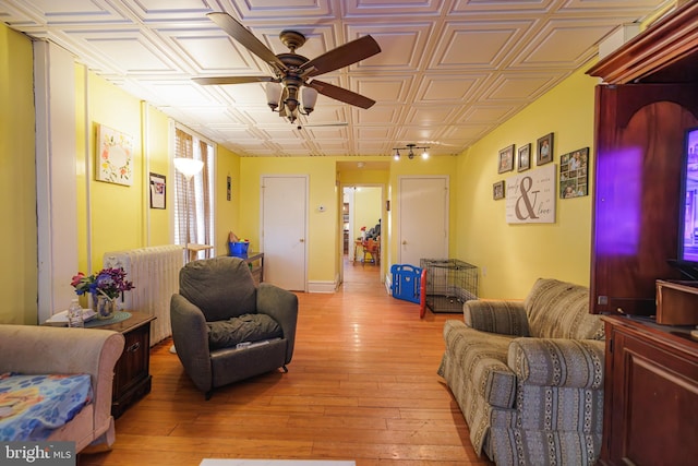 living room featuring light hardwood / wood-style flooring and ceiling fan