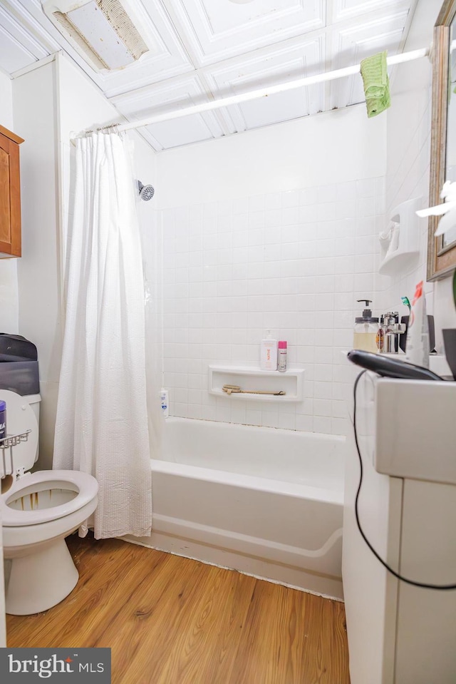 bathroom with shower / tub combo with curtain, toilet, and hardwood / wood-style floors