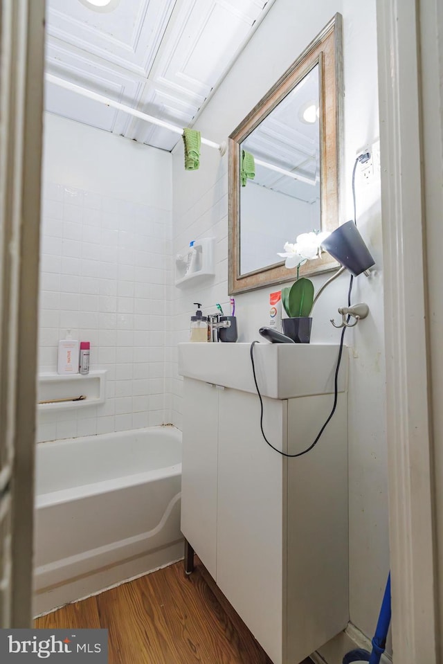 bathroom featuring vanity, hardwood / wood-style floors, and a tub