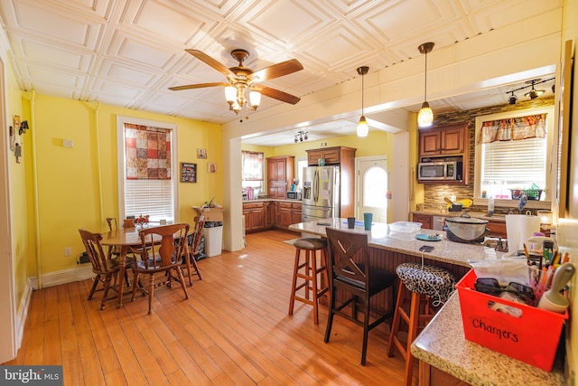 dining space with ceiling fan and light hardwood / wood-style floors