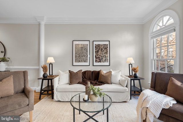 living room featuring crown molding, hardwood / wood-style flooring, and ornate columns