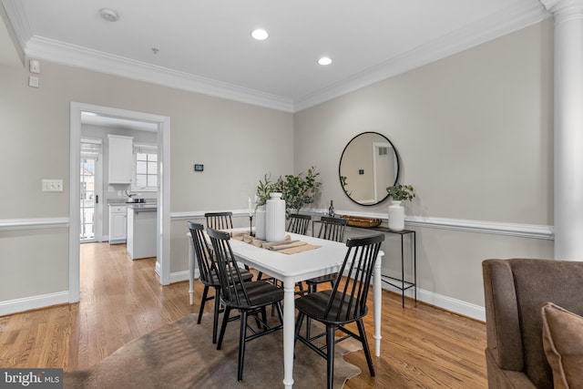 dining room featuring light hardwood / wood-style flooring and ornamental molding