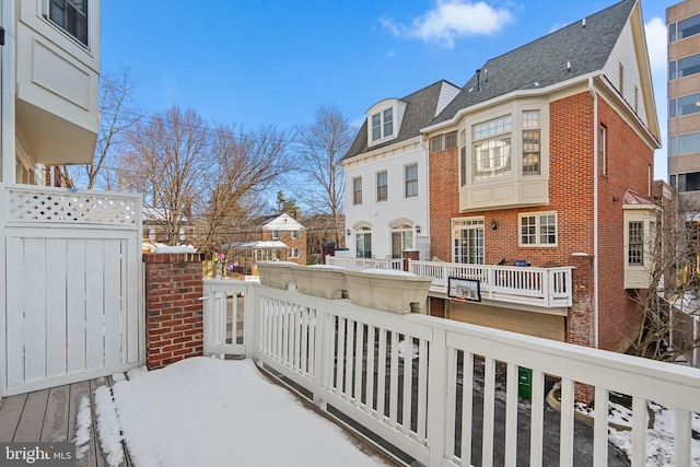 view of snow covered back of property