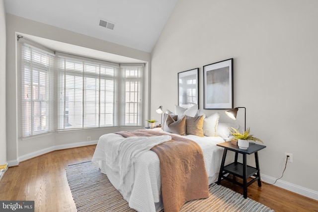 bedroom with hardwood / wood-style floors and vaulted ceiling