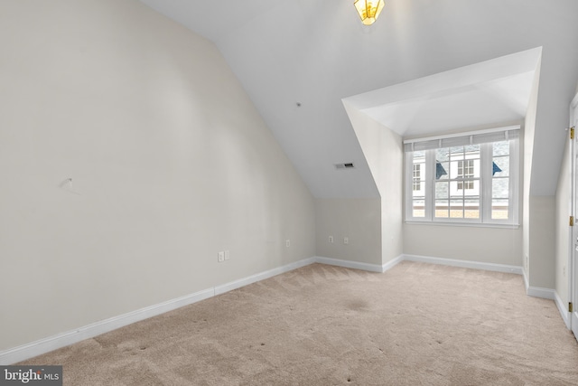 bonus room featuring light colored carpet and vaulted ceiling