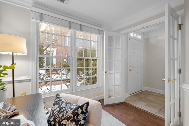 doorway to outside with wood-type flooring and crown molding