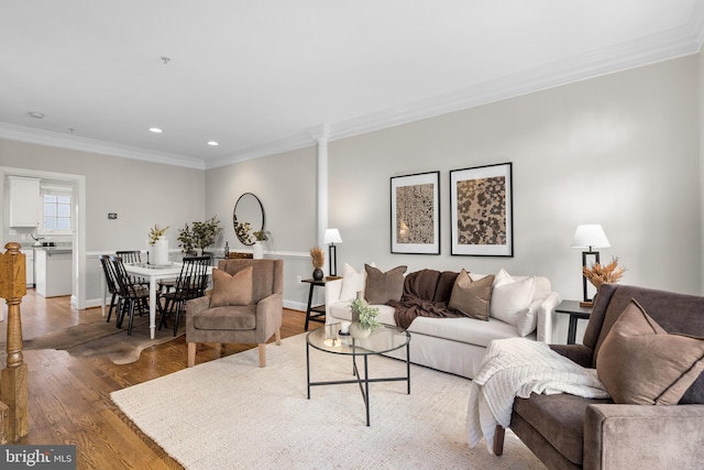 living room with ornate columns, ornamental molding, and hardwood / wood-style floors