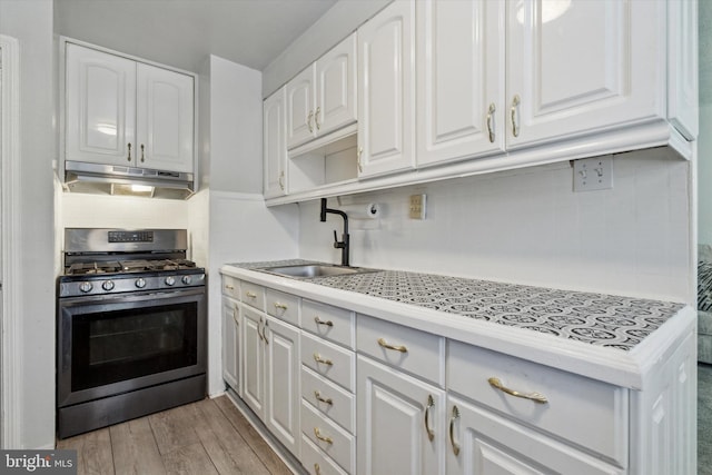 kitchen with white cabinetry, stainless steel range with gas cooktop, light hardwood / wood-style floors, and sink