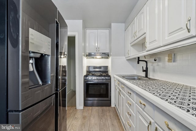 kitchen with sink, white cabinetry, tasteful backsplash, light hardwood / wood-style flooring, and stainless steel appliances