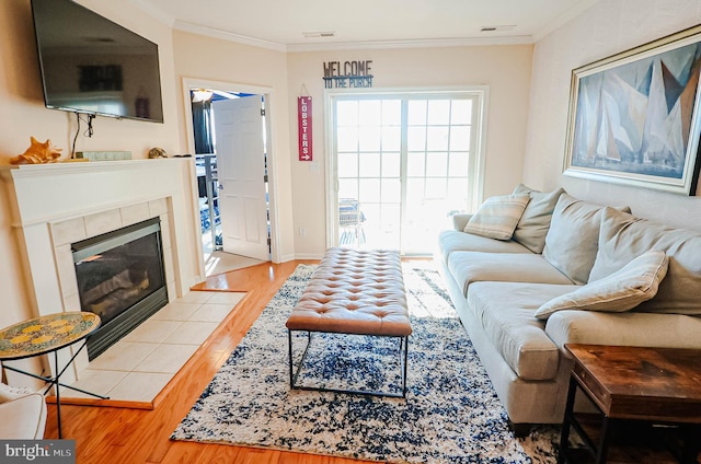 living room with hardwood / wood-style floors, a fireplace, and ornamental molding