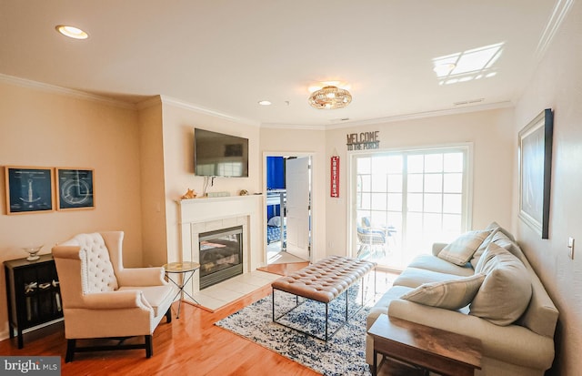 living room featuring hardwood / wood-style flooring, a fireplace, and crown molding