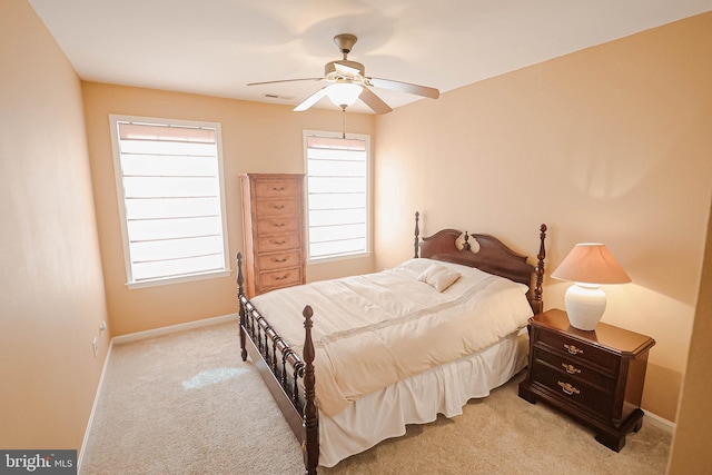 carpeted bedroom with multiple windows and ceiling fan