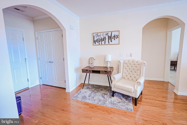 living area featuring crown molding and hardwood / wood-style floors