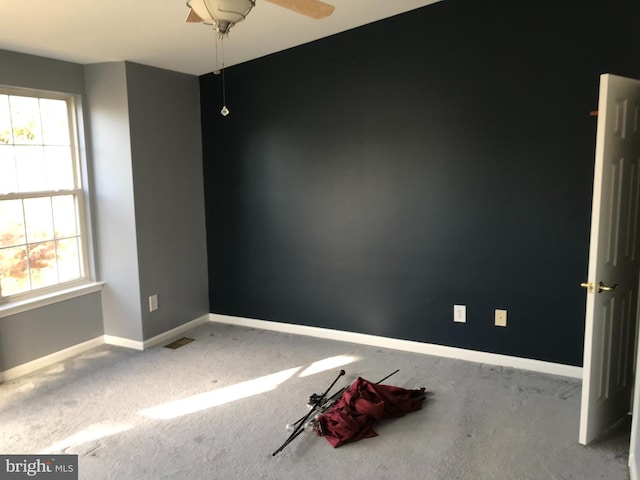 unfurnished room featuring ceiling fan and a wealth of natural light