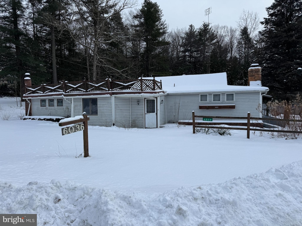 view of snow covered back of property