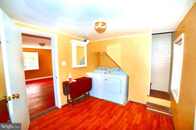 clothes washing area with wood-type flooring and washer and dryer