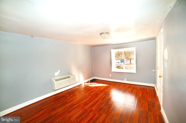 spare room featuring a wall mounted air conditioner and wood-type flooring